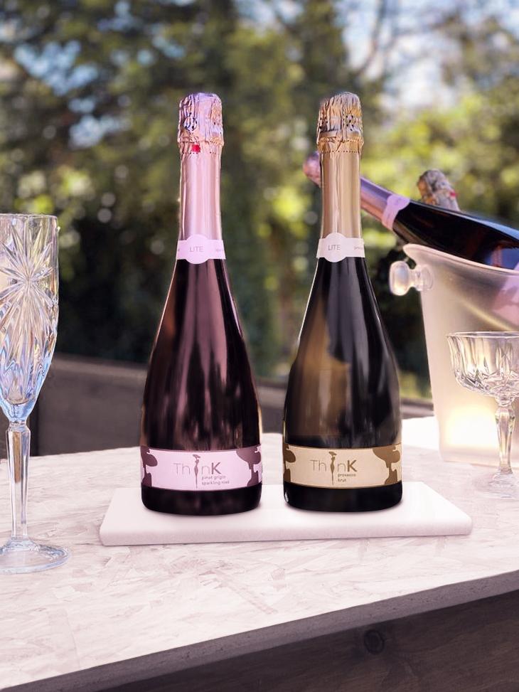 Two bottles of Organic Vegan Sparkling Wine (75 calories each) resting on a marble table