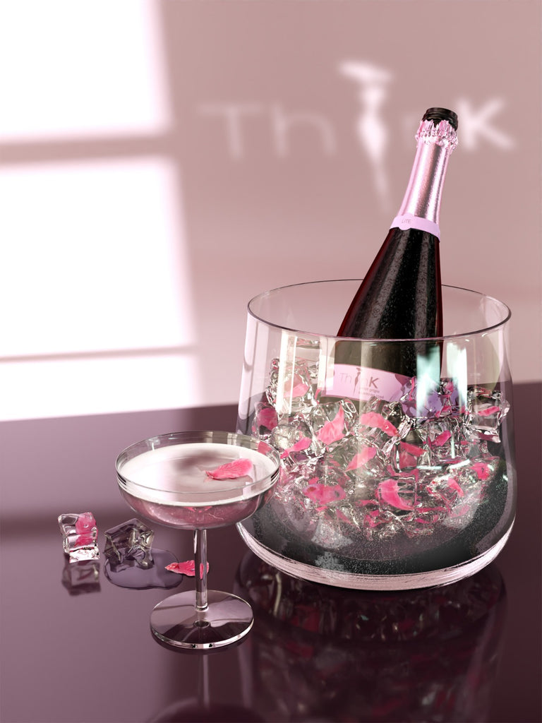 A bottle of 75cl Organic Vegan Sparkling Rosé next to a glass of wine resting on a table